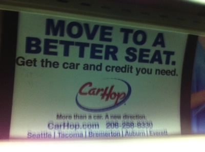 Photo of a transit ad that states: Move to a Better Seat. Get the car and credit you need. Car Hop. More than a car. A new direction. CarHop.com 206-258-8330 Seattle | Tacoma | Bremerton | Auburn | Everett